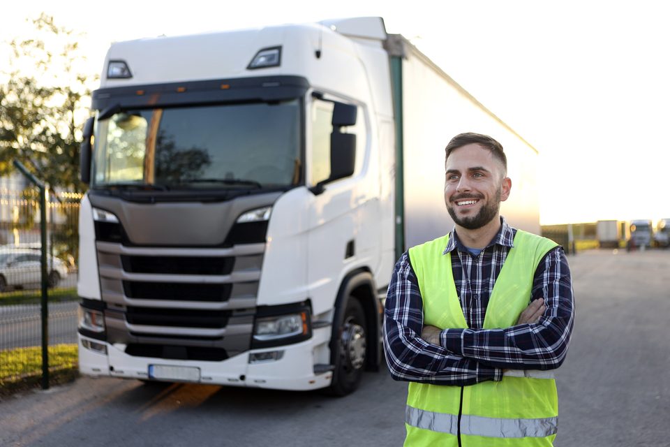 Fahrer in Warnweste vor seinem Sattelzug