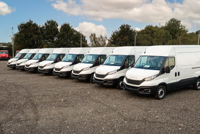 Reihe weißer Transporter auf einem Betriebshof