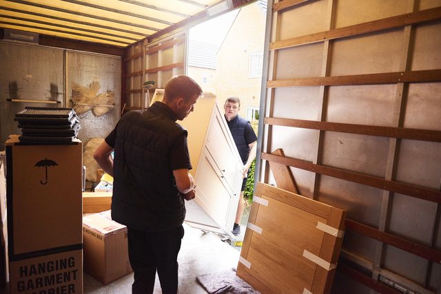 Möbel und Kartons werden in einen Umzugswagen geladen